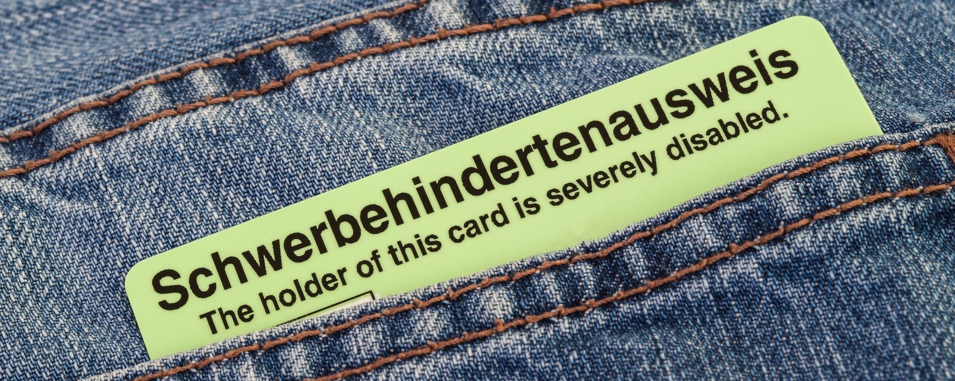 Ein Schwerbehindertenausweis steckt in einer Jeans-Hosentasche